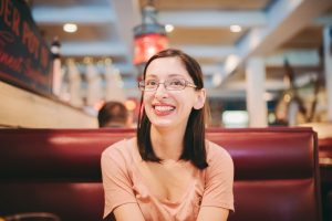 Young millennial woman, happy, at a restaurant waiting for food